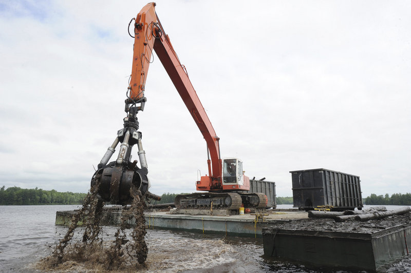 Todd Bernier operates a long reach excavator at Quakish Lake near Millinocket as the company harvests its raw materials.