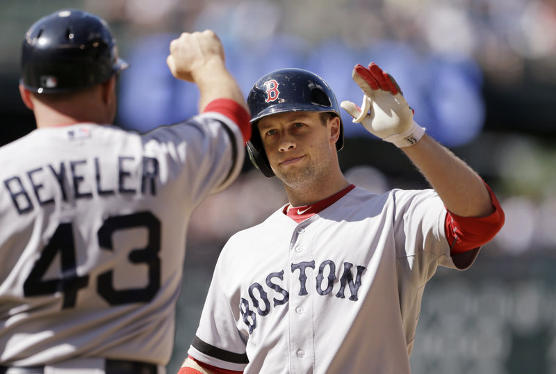 Boston’s Daniel Nava, right, is congratulated by first-base coach Arnie Beyeler after hitting an RBI single in the 10th inning to give the Red Sox an 8-7 win over the Mariners.