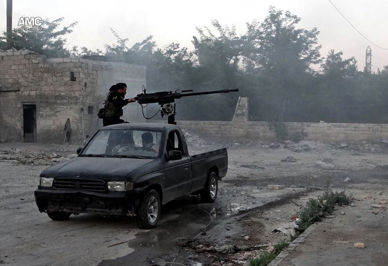 A Syrian rebel fires a heavy machine gun toward Syrian soldiers loyal to President Bashar Assad in Aleppo last month. Rebel forces have been falling back.