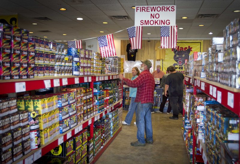 People shop for fireworks at the Pyro City retail store in Winslow on June 28. The government reported Monday that U.S. retail sales slowed in June.