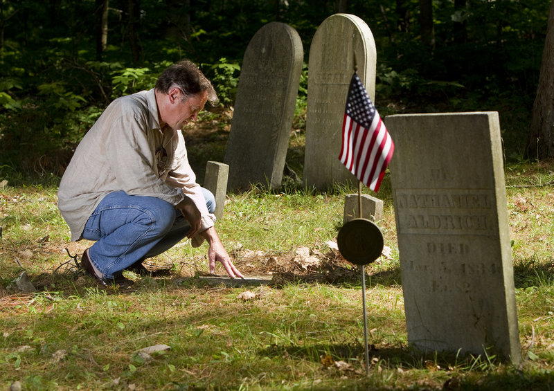 Film producer Frank Pote, who is undertaking a documentary about the Captain Greenfield Pote House, the oldest house in Freeport, examines a gravestone near the home Monday July 15, 2013.