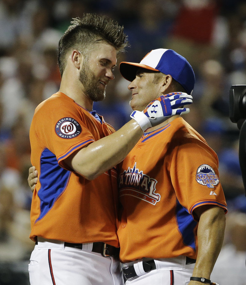 Bryce Harper, left, of the Washington Nationals, embraces his father, Ron, at the end of the third round of the All-Star baseball Home Run Derby. Harper finished second to Oakland’s Yoenis Cespedes.