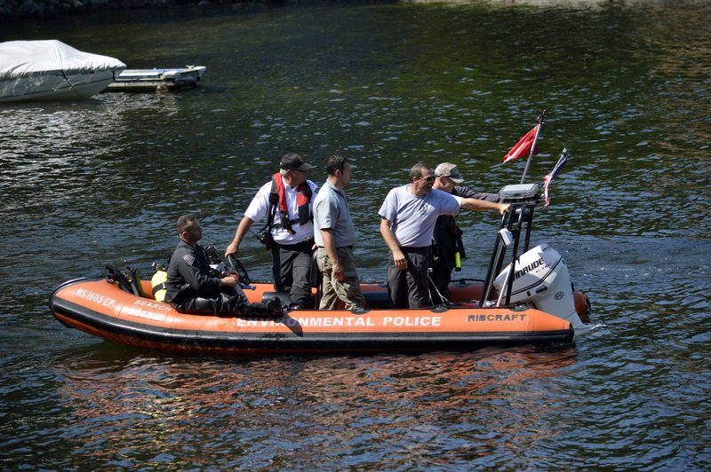 Massachusetts and New York State Police dive teams head out on Greenwater Pond to search for the body of James "Jamie" Lusher Tuesday, July, 16, 2013, in Becket, Mass. Lusher was 16 when he disappeared in Westfield, Mass., on Nov. 6, 1992. The search comes a day after authorities announced that Lewis Lent Jr., serving a life sentence for killing two children, confessed to killing Lusher. (AP Photo/Berkshire Eagle, Ben Garver)
