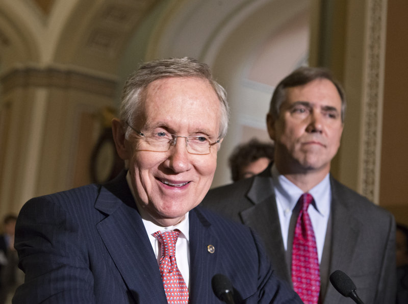 Majority Leader Harry Reid, D-Nev., left, joined by Sen. Jeff Merkley, D-Ore., speak to reporters Tuesday after the Senate stepped back from the brink of a political meltdown.