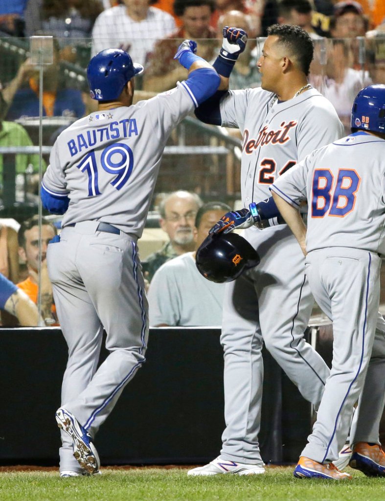 Miguel Cabrera of the Detroit Tigers is congratulated by Jose Bautista of the Toronto Blue Jays after scoring on Bautista’s sacrifice fly during the fourth inning of the American League’s 3-0 victory in the All-Star game at Citi Field in New York.
