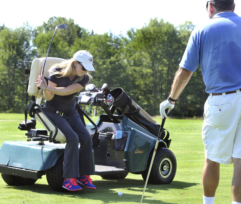 Monica Quimby of Scarborough hits the ball from an adaptive golf cart. Quimby, a paraplegic, is able to drive the car and adjust the swivel seat using hand controls.