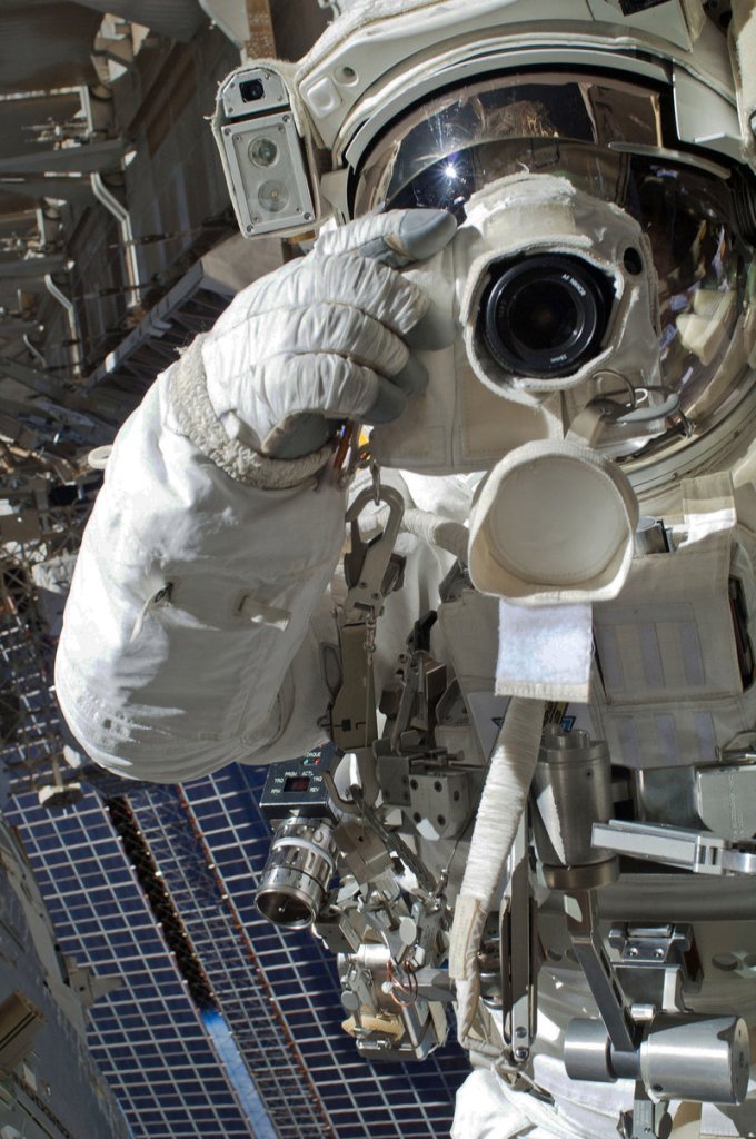 Astronaut Chris Cassidy uses a still camera during a spacewalk Tuesday outside the International Space Station. A short time later, Italian astronaut Luca Parmitano, not in frame, reported an unusual buildup of water inside his helmet and the walk had to be aborted.