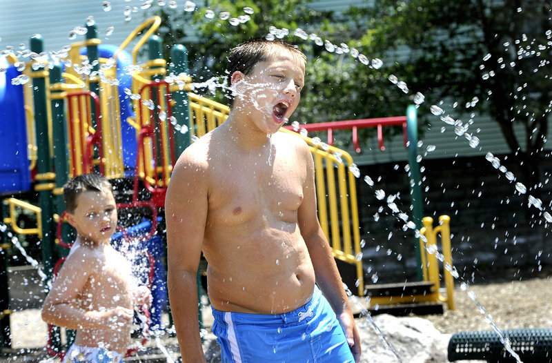 Brothers Jared Payer, 7, left, and Jayce Gerry, 10, of Portland have fun while keeping cool at the Stone Street Playground in Portland. The city’s high temperatures have ranged from the mid-80s to the low 90s since Sunday. Friday’s high is expected to be 94 degrees.
