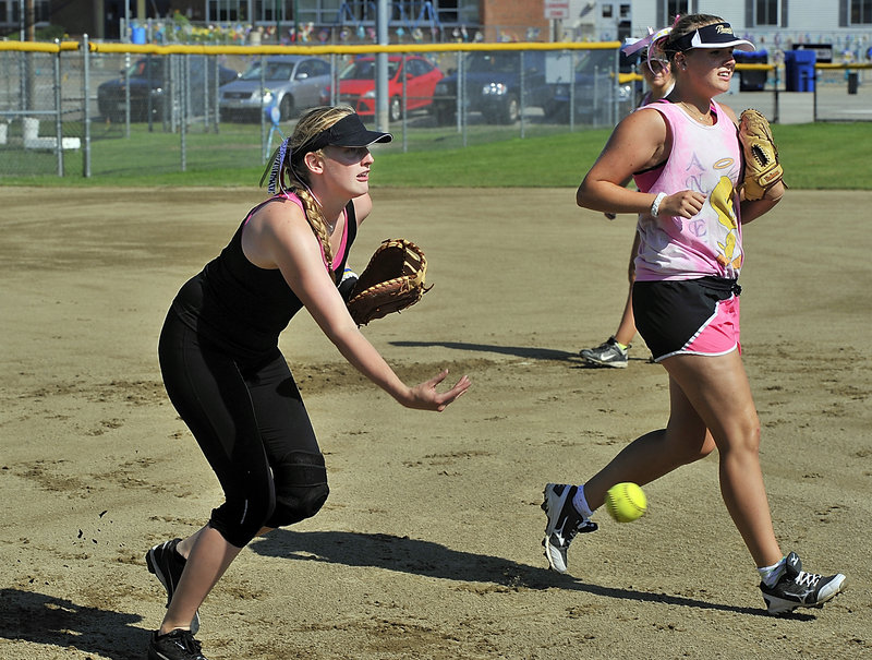 Emilia Wallen makes a low toss to first base during a bunt drill as her teammate and sister, Amanda, also participates with the team of Swedish softball players.