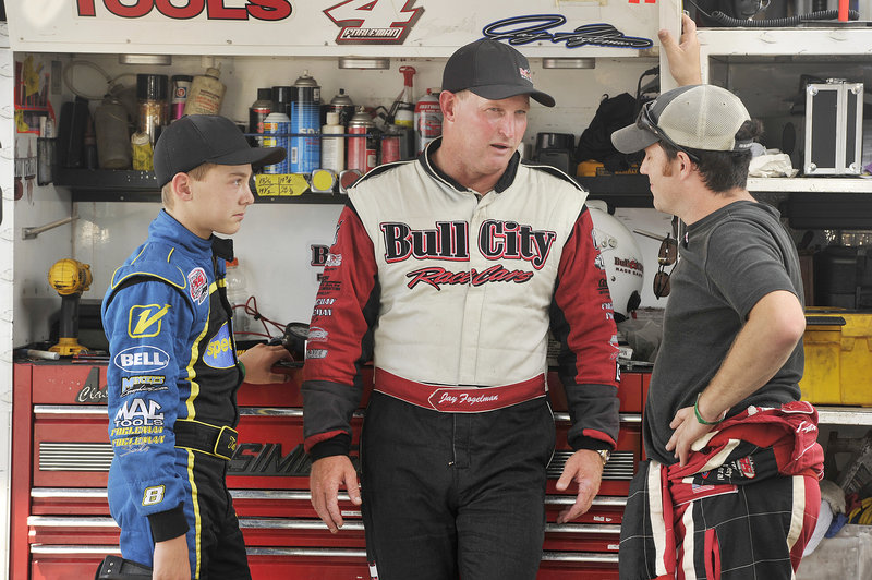 Jay Fogleman, center, and his son, 13-year-old Tate, discuss the day’s practice runs with another team member at Oxford Plains Speedway in preparation for Sunday’s TD Bank 250. Jay’s father, 71-year-old Kent Fogleman, is a retired racer who will be in the stands.