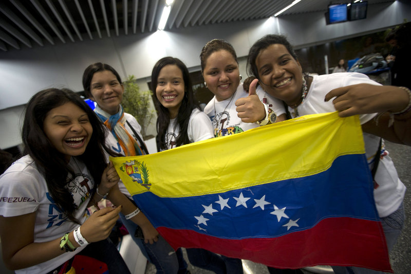 Venezuelans hold a replica of their country’s flag after arriving Friday at the international airport in Rio de Janeiro, Brazil. Thousands of young Roman Catholics from around the Americas are converging on the city for World Youth Day and the arrival of Pope Francis, who plans to visit Manguinhos on Monday.