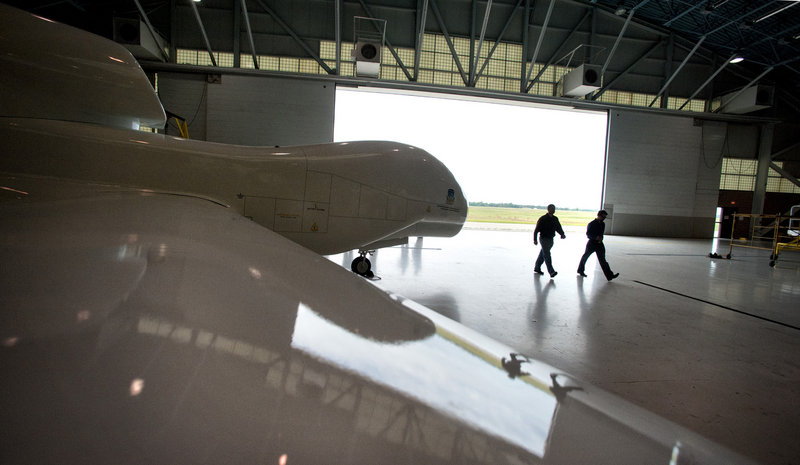 Two instructors pass a model of a Northrop Grumman Global Hawk at Northland Community and Technical College in Thief River Falls, Minn. The Air Force tried but failed to scuttle the Global Hawk program.