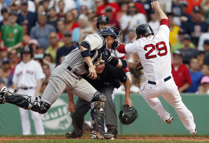 Yankees catcher Chris Stewart extends to put the tag on Boston’s Daniel Nava during the first inning of a 5-2 Yankees’ win at Fenway Park on Saturday afternoon. The two teams wind up their three-game series Sunday at 8:05 p.m.