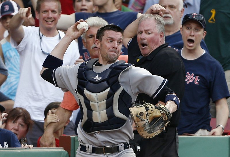 Yankees catcher Chris Stewart, who had just dived into the stands to catch a foul pop, whirls to throw out Boston’s Daniel Nava, who was trying to tag and advance to second.