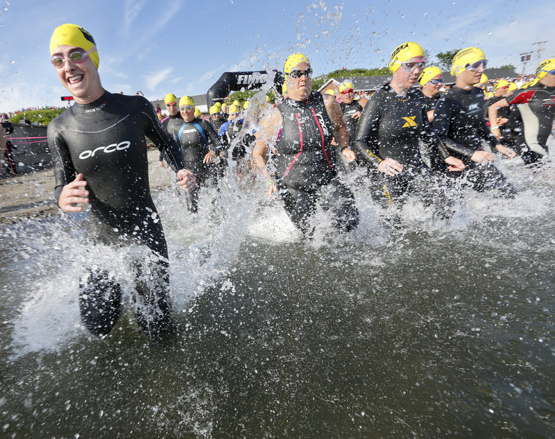 Bernadette Shaw of Cape Elizabeth and others enter the water in the yellow caps group of women ages 35-39 in the Maine Cancer Foundation’s Tri for a Cure in South Portland on Sunday. In its sixth year, the event was expected to raise $1.2 million.