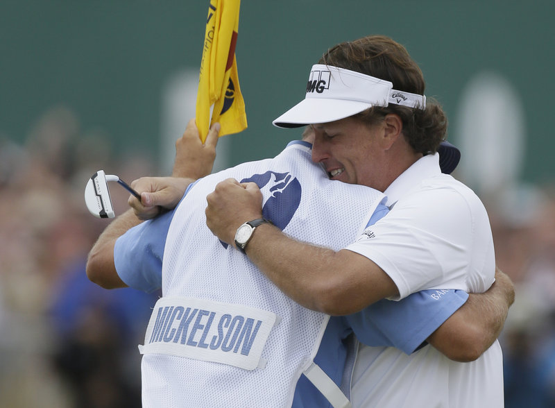 Phil Mickelson embraces his caddy, Jim Mackay, after winning the British Open for the first time on Sunday.