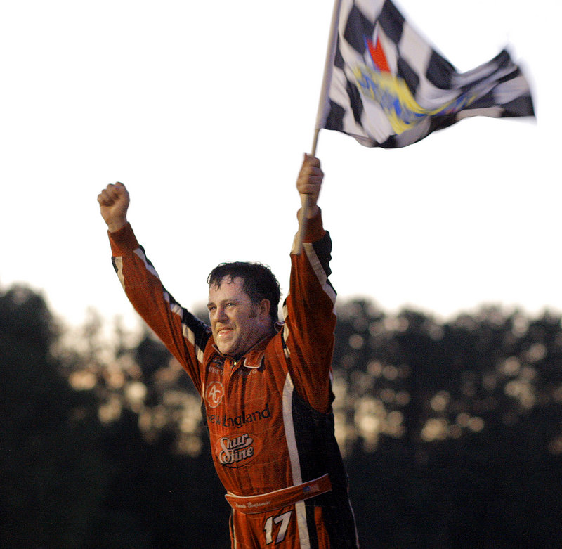 Travis Benjamin of Morrill is a happy driver as he waves the checkered flag after winning the 40th TD Bank 250 at Oxford Plains Speedway on Sunday.