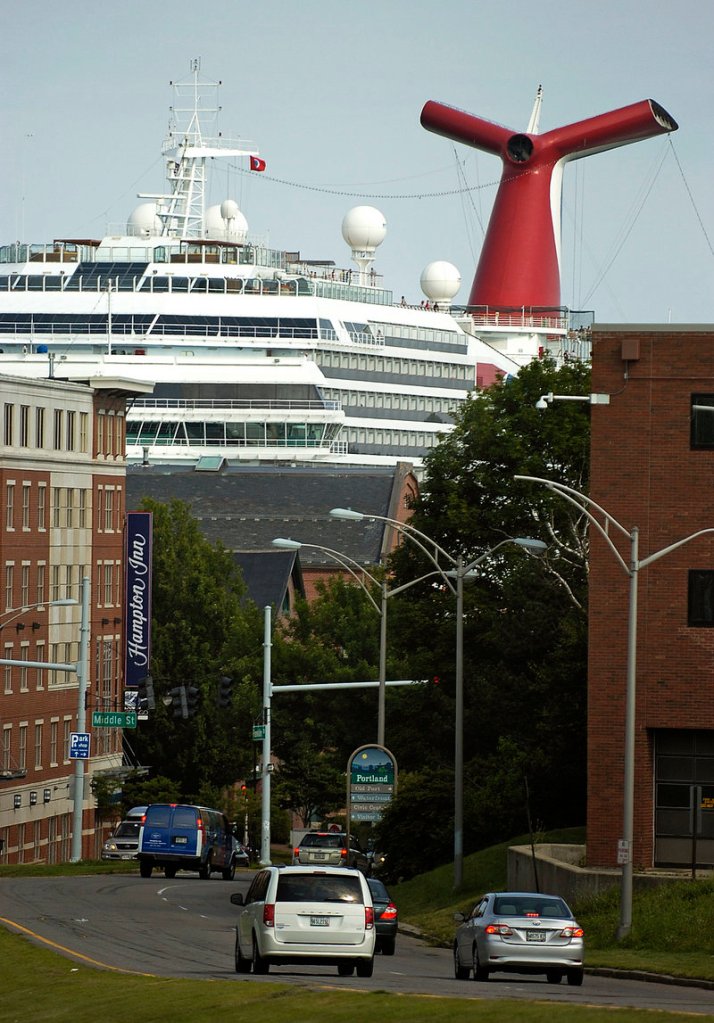 The Carnival Glory towers over the Portland waterfront Monday in this view from the corner of Franklin and Congress streets. The ship has a capacity of 2,984 passengers and a crew of 1,150, according to Carnival Cruise Lines.