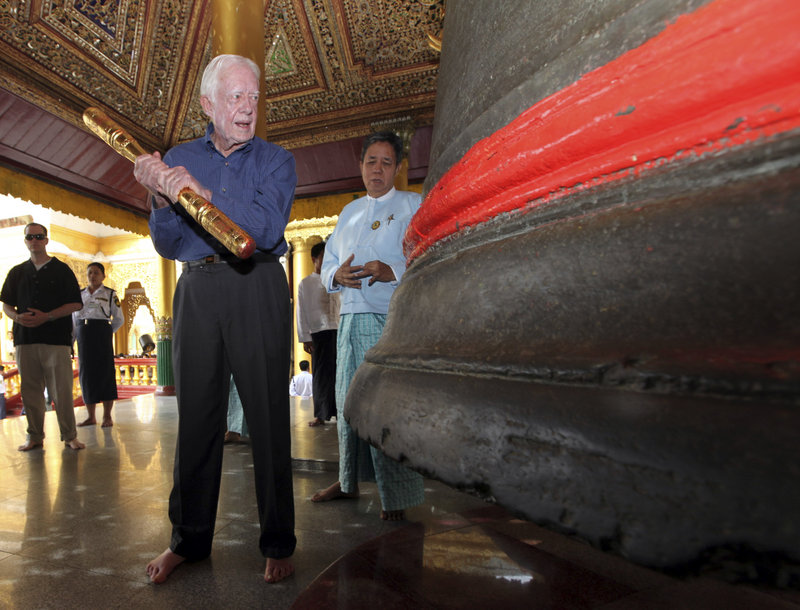 Former President Jimmy Carter prepares to ring a bell during his April 2013 visit to the famed Shwedagon Pagoda in Yangon, Myanmar, formerly known as Burma.