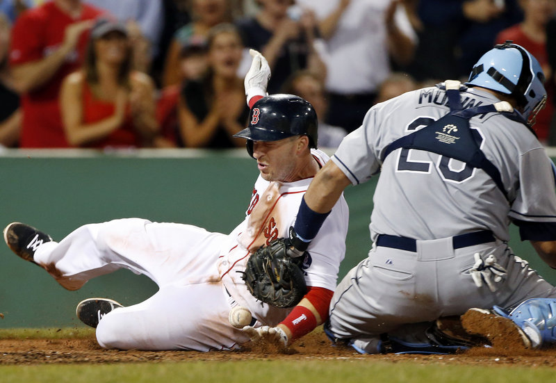 Stephen Drew of the Boston Red Sox slides around Tampa Bay catcher Jose Molina, who couldn’t control the ball, to score on Jose Iglesias’ eighth-inning single Tuesday night, part of a three-run inning that put away a 6-2 victory at Fenway Park.