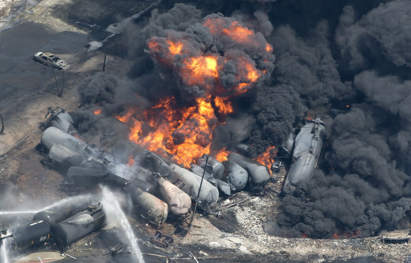 Smoke rises after railway cars carrying crude oil derailed in Lac-Megantic, Quebec, on July 6. A reader blames the derailment on “the ridiculously dangerous practice of parking a train on a main running line,” rather than on a siding or in a rail yard.