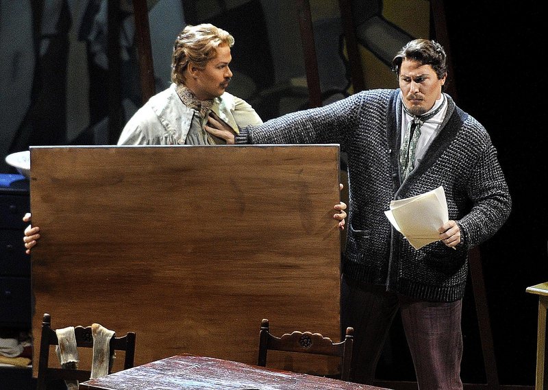 Edward Parks, in the role of Marcello, is held off by Jeff Gwaltney, as Rodolfo, in the opening performance of Puccini’s “La Boheme” at Merrill Auditorium in Portland on Wednesday. Director Dona D. Vaughn gives the opera a contemporary feel.