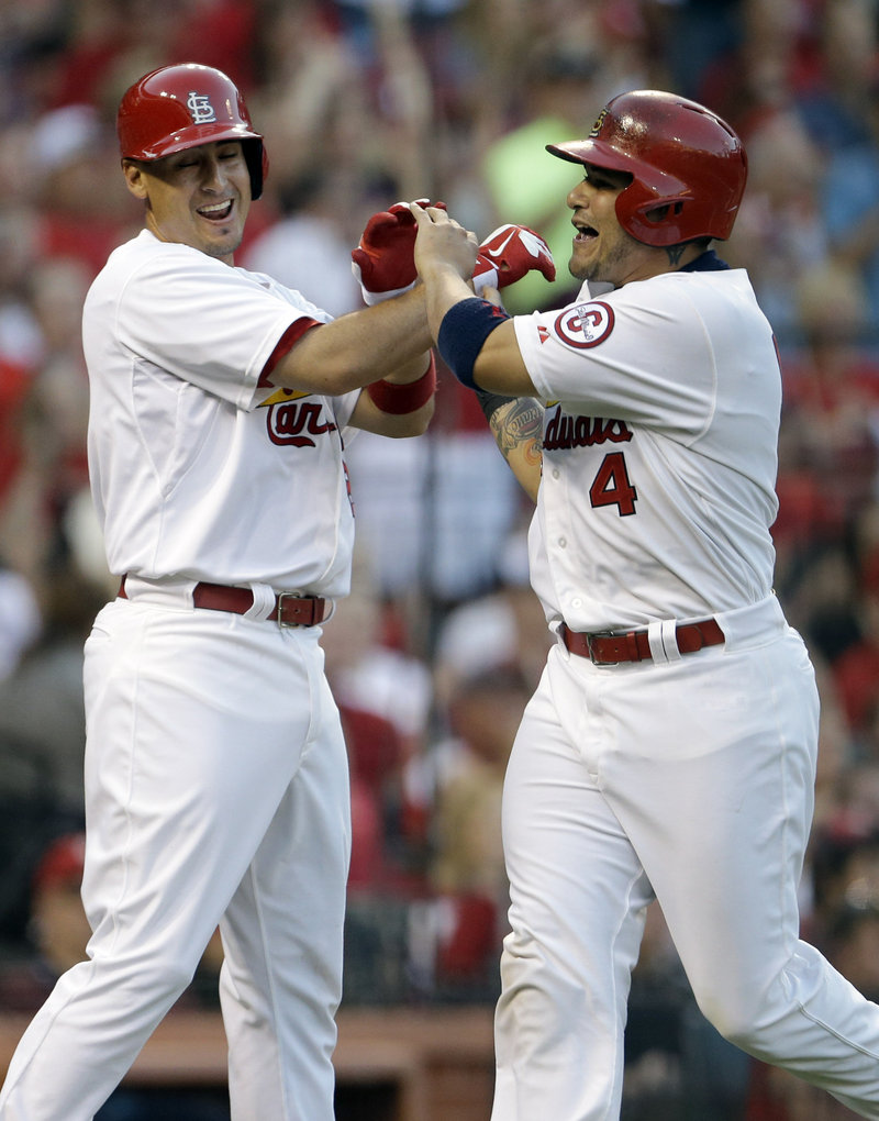 Allen Craig, left, and Yadier Molina celebrate after scoring on a hit during the Cardinals’ win over the Phillies.