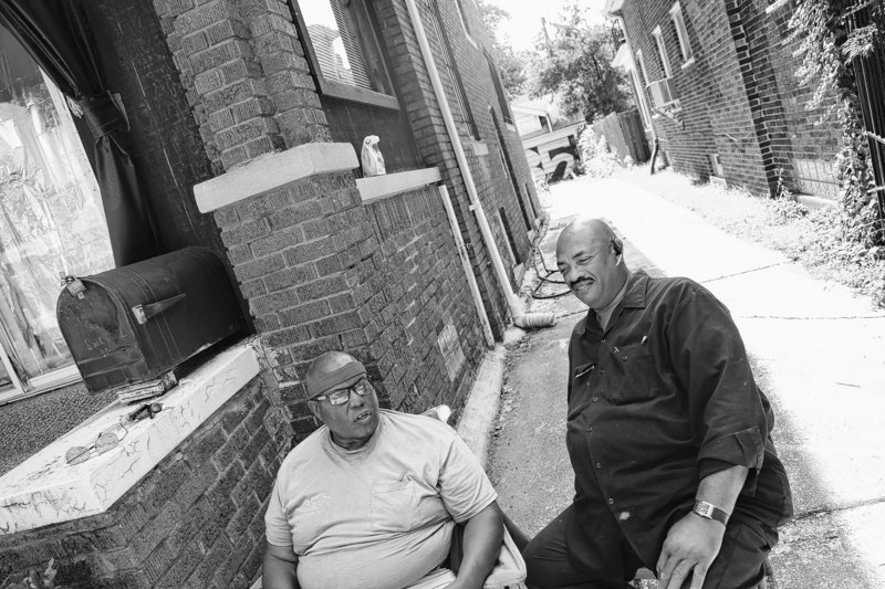 James Jackson, 65, left, and his friend Harry Jolliffi Sr., 63, sit in front of Jackson’s home after patrolling their Jefferson-Chalmers neighborhood in Detroit on Friday.