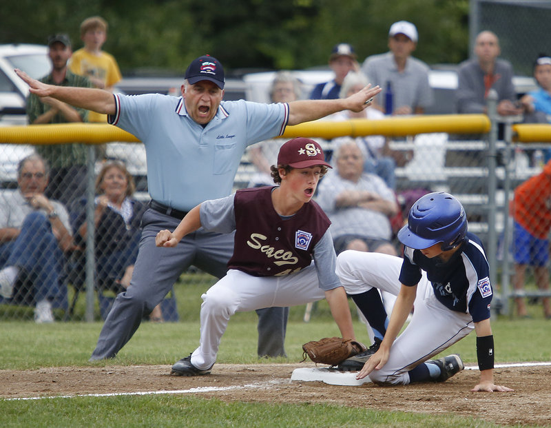 Lou Dublin, the third-base umpire, is emphatic with his safe call Thursday night as Owen Burke of Bayside of Portland slides under a tag applied by Michael Bourgault of Saco in the second inning. Saco won 12-4, setting up a final game for the Little League state title.