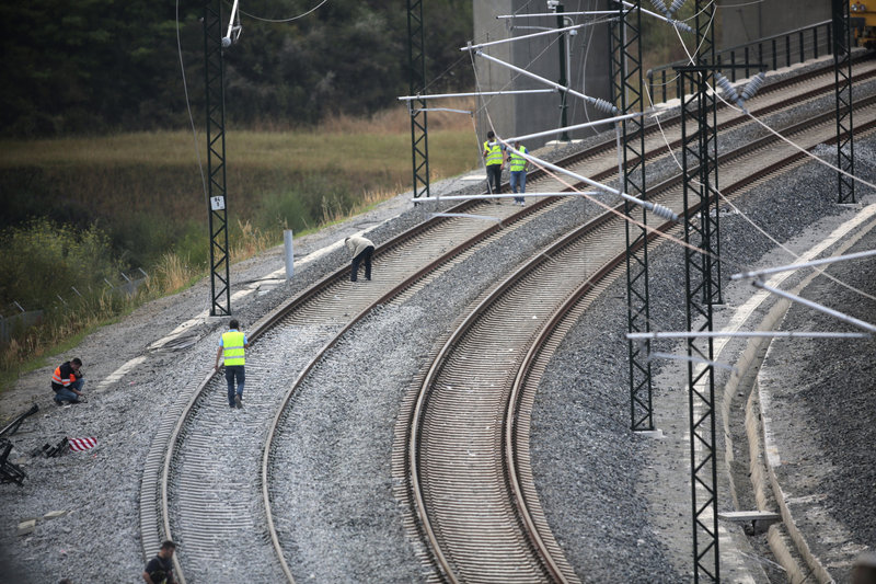 Workers stand on the track at the site of a fatal train crash in Santiago de Compostela, northwestern Spain, on Friday.