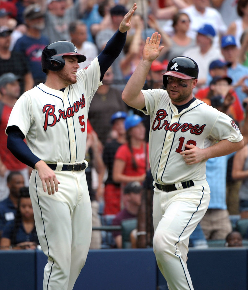 Freddie Freeman, left, greets Brian McCann after they scored on a double by Andrelton Simmons in the eighth inning to give Atlanta a 2-0 win over St. Louis.