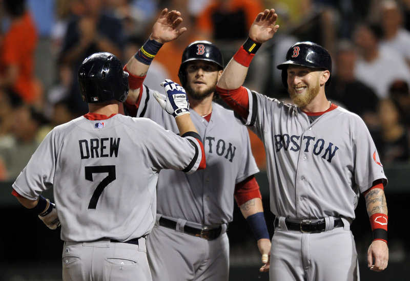 Stephen Drew is congratulated by teammates Jarrod Saltalamacchia, center, and Mike Carp after hitting a three-run homer Saturday night in the fourth inning of a 7-3 victory for the Boston Red Sox against the Baltimore Orioles.