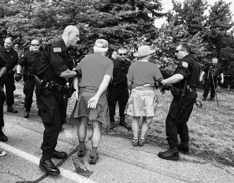 Anti-coal protesters are taken into custody as they set foot on the property of the Brayton Point Power Station in Somerset, Mass., Sunday.