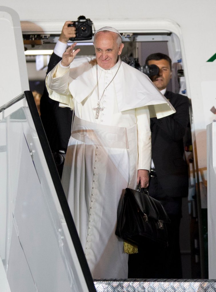 Pope Francis waves as he boards his plane at the airport in Rio de Janeiro on Sunday after a weeklong visit to Brazil.