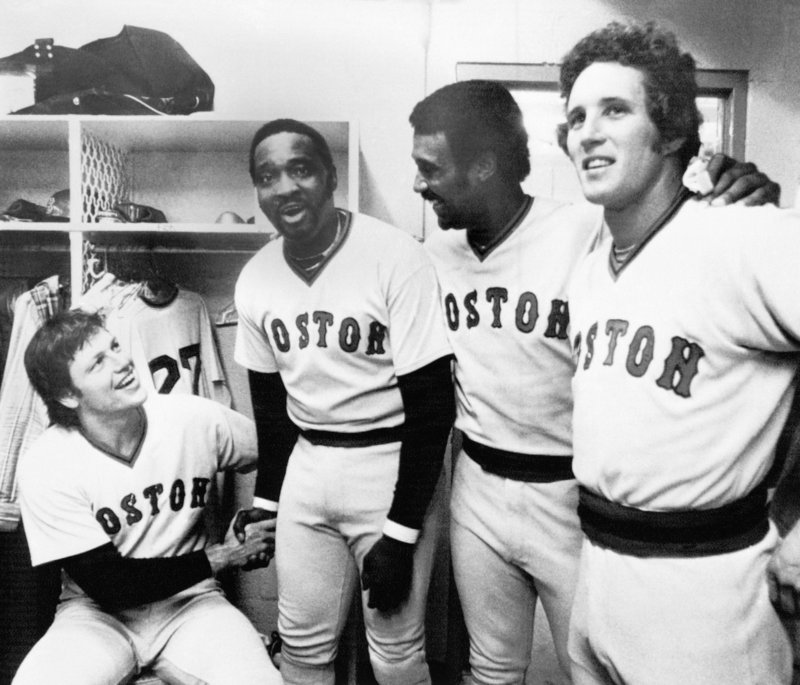 George Scott, second from left, clasps hands with catcher Carlton Fisk while outfielder Jim Rice and infielder Butch Hobson join in some clubhouse camaraderie in this 1977 photo.