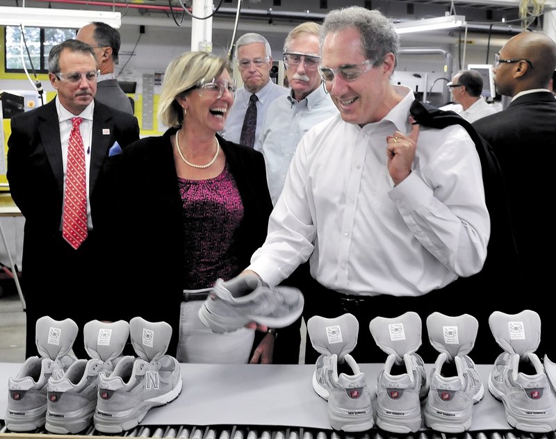 Trade Representative Michael Froman, right, examines a sneaker in front of some of Maine’s elected officials and New Balance company officials at the production plant in Norridgewock on Monday.