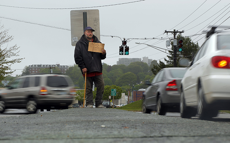 In this file photo, Don Dietz, 48, panhandles for change in the median at the corner of Franklin Street and Marginal Way in Portland on Friday, May 24, 2013.