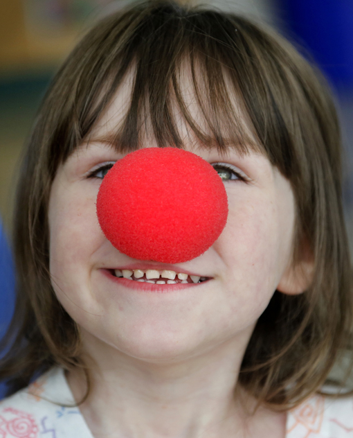 Kaitlyn Frost, 4, of Waterville tries on a clown nose as members of Circus Smirkus Big Top Tour make a stop at The Barbara Bush Children's Hospital at Maine Medical Center on Sunday.