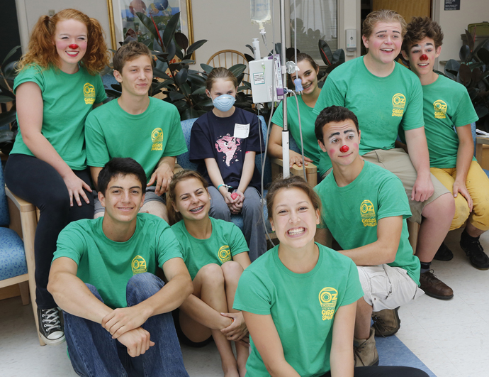 Makenzie Tompkins, 11, of Old Orchard Beach poses for a photo with members of Circus Smirkus Big Top Tour as they make a stop at The Barbara Bush Children's Hospital on Sunday.