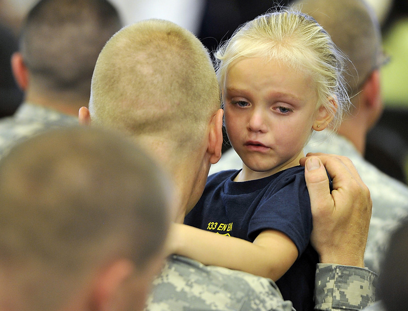 Sgt. Mark Thibeault listens to the words of his emotional daughter, Tatyanah, 3, prior to the start of Saturday's send-off ceremony for the 133rd Engineer Battalion and 1035th Engineer Survey and Design Team.