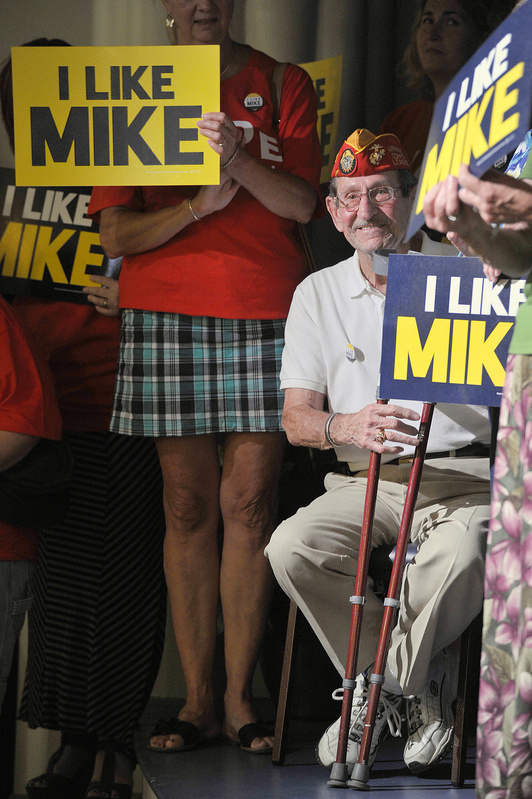 Maurice “Mo” Marquis, wearing a Marine Corps League cap, shows his approval of U.S. Rep. Mike Michaud’s run for governor at the Franco-American Heritage Center in Lewiston on Thursday. The Democrat’s rivals, incumbent Republican Gov. Paul LePage and independent Eliot Cutler, promise a challenging race.
