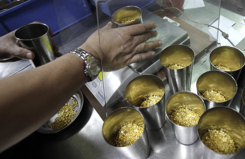 A technician prepares containers of gold grains for melting into in Dubai, United Arab Emirates.