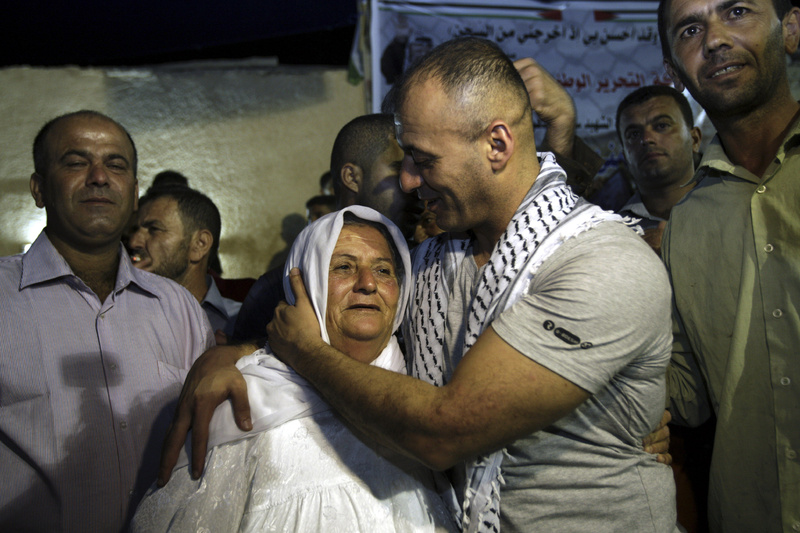 Burhan Sbeih, a released Palestinian prisoner, kisses his mother at his home in the West Bank village of Kofr Raei near Jenin city after his release Wednesday.
