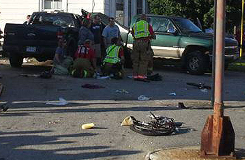 Rescuers attend to one of the victims at the scene of the crash in Biddeford on Friday. David LaBonte’s Ford F-150 truck is at left and one of the bicycles lies in the foreground.