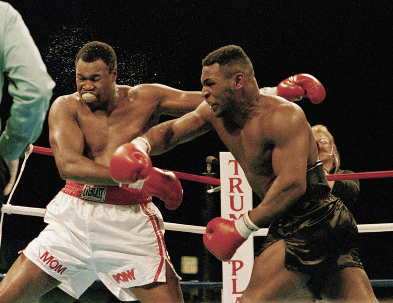 Mike Tyson, right, follows through on a punch to Larry Holmes during a heavyweight title boxing fight in Atlantic City, N.J., in 1988. Tyson now is a promoter. Boxer,Boxing,Punching,Ring,Rope,Strength,Violence