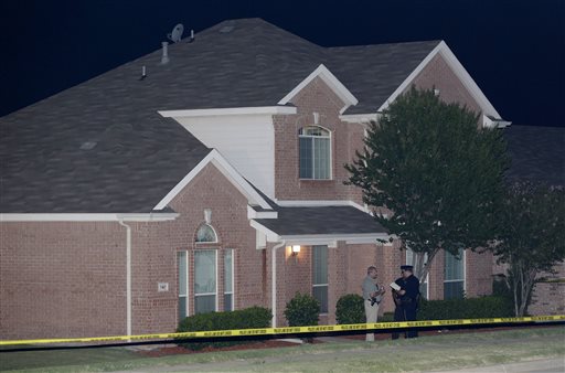 Law enforcement officers confer early Thursday morning outside the house where a fatal shooting took place in DeSoto, Texas.