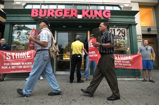 Protesters display placards outside a Burger King fast-food restaurant in Boston on Thursday. The protest was one of several planned in Boston.