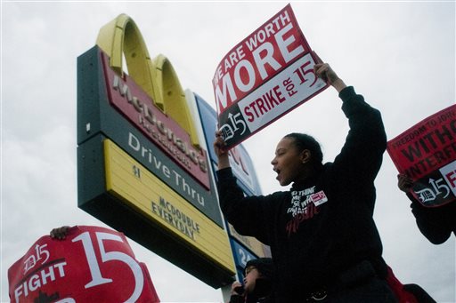 Fast-food worker Michelle Osborn, 23, of Flint shouts out chants as she and a few dozen others strike outside of McDonald's on Wednesday, July 31, 2013 in Flint. Some fast food restaurant workers have walked off the job in the Detroit area as part of an effort to push for higher wages. Organizers say they began the walkout at restaurants in Lincoln Park and Southfield on Tuesday night. Workers in Flint hit the street Wednesday outside a McDonald's, saying they want wages "super-sized." Workers want $15 and hour, better working conditions and the right to unionize. The restaurant industry says higher wages would hurt job creation. The actions follow strikes this week in other parts of the country. (AP Photo/The Flint Journal, Jake May)