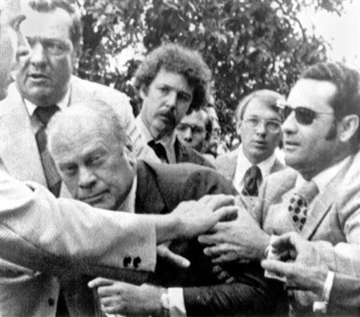 In this Sept. 5, 1975, photo, President Gerald Ford is shielded by the Secret Service after an assassination attempt by Lynette "Squeaky" Fromme. Ford had spoken at a "Host Breakfast," and was walking to California's state Capitol in Sacramento when the attempted assassination took place.