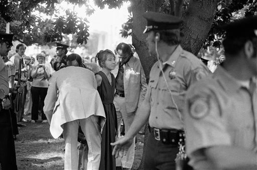 Lynette "Squeaky" Fromme is taken into custody. Fromme, a devoted follower of the infamous Charles Manson, wearing a red robe, stepped out from behind a tree and pointed a loaded pistol at the president.